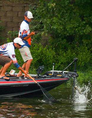 Jordan Lee battles a bass while his brother, Matt, waits with the net. 