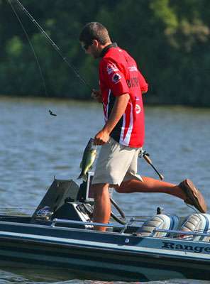 Lasher moves to the front of the boat to measure the fish. 